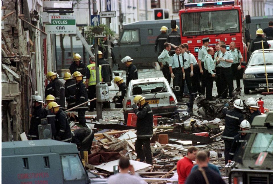 Police officers and firefighters inspecting the damage caused by a bomb explosion in Market Street, Omagh
