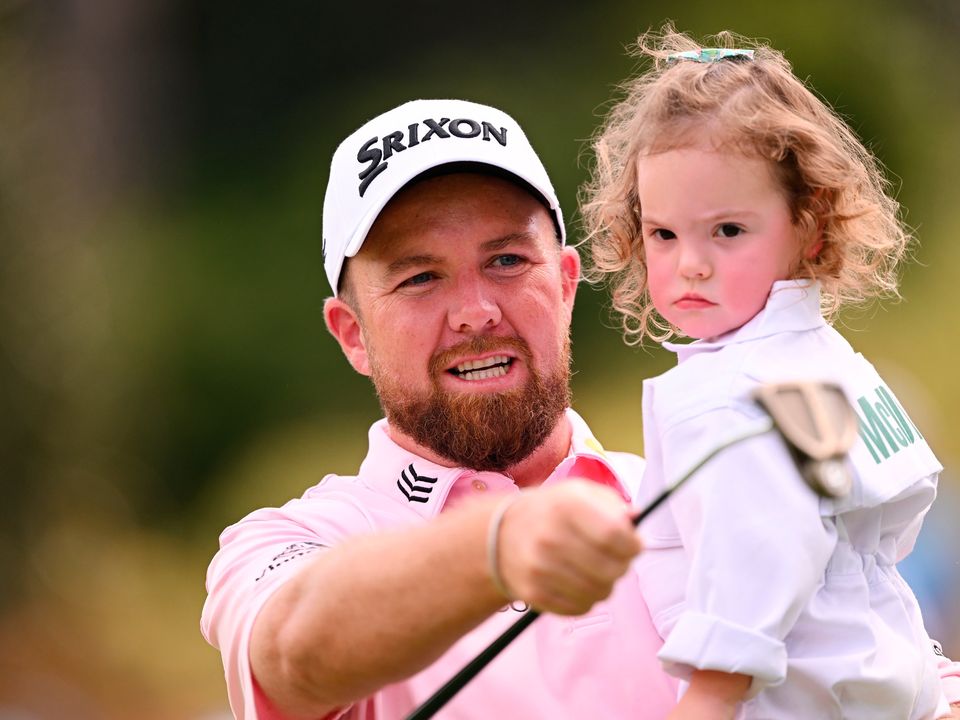 Shane Lowry looks on with Rory McIlroy's daughter Poppy on the first hole during the Par 3 contest at Augusta National. (Photo by Ross Kinnaird/Getty Images)