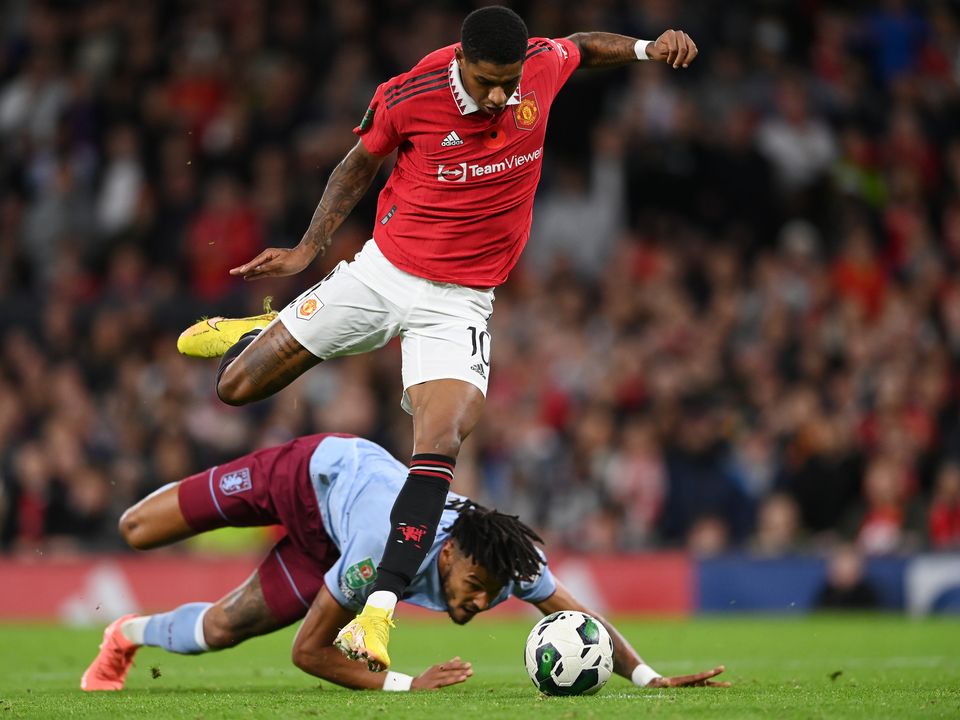 MANCHESTER, ENGLAND - NOVEMBER 10: Marcus Rashford of Manchester United jumps over Tyrone Mings of Aston Villa on their way to scoring their team's second goal during the Carabao Cup Third Round match between Manchester United and Aston Villa at Old Trafford on November 10, 2022 in Manchester, England. (Photo by Stu Forster/Getty Images)