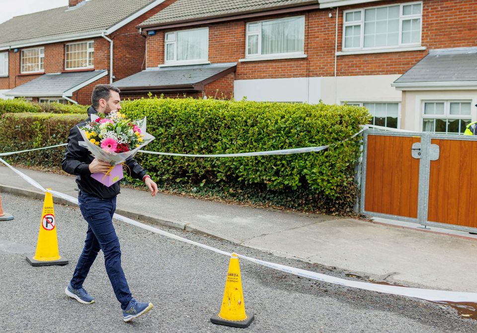 Local Fine Gael activist Blaine Gaffney arriving with flowers at the scene where the body of man in his 30s was found in house at Cartron, Sligo in ‘unexplained circumstances’ Photo: James Connolly