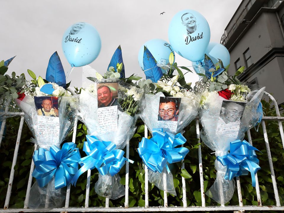 SHOOTING: Floral tributes on the railings of the Regency Hotel, where gunmen killed David Byrne