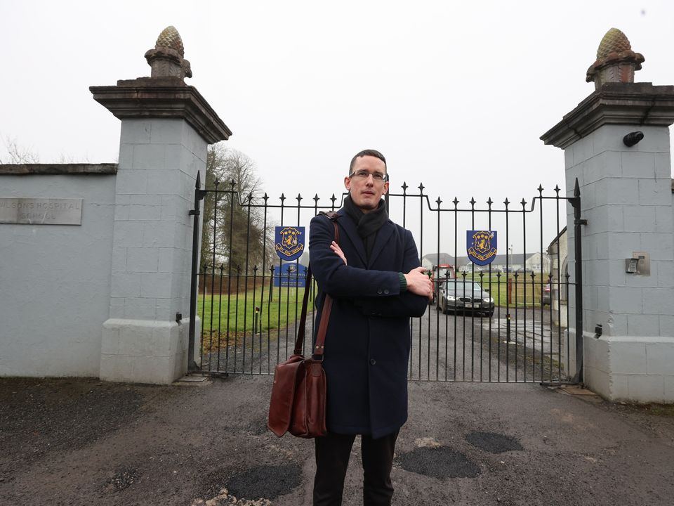 Dismissed teacher Enoch Burke outside the locked gates of Wilson's Hospital School in Westmeath on Tuesday afternoon. Photo: Gerry Mooney