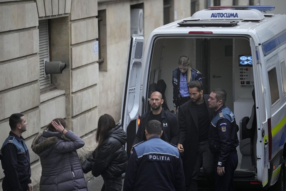 Andrew Tate, centre, and his brother Tristan, second right, are brought by police officers to the Court of Appeal, in Bucharest, Romania, on Tuesday. AP