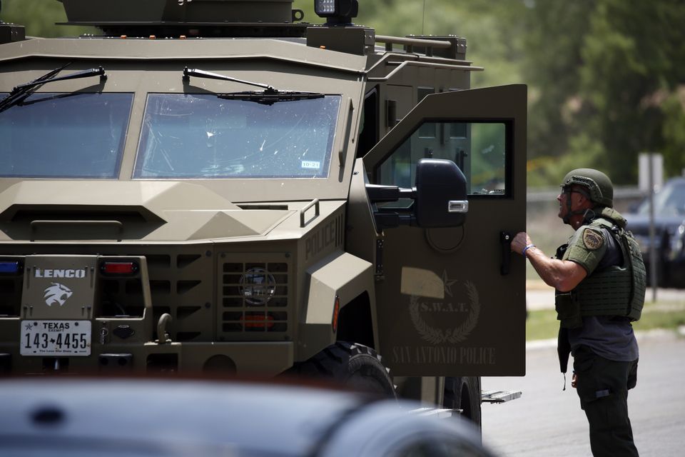 Law enforcement personnel stand next to an armoured vehicle outside the school (Dario Lopez-Mills/AP)