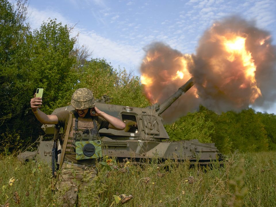 A Ukrainian soldier takes a selfie as an artillery system fires in the front line in Donetsk region, eastern Ukraine, Saturday, Sept. 3, 2022. (AP Photo/Kostiantyn Liberov)