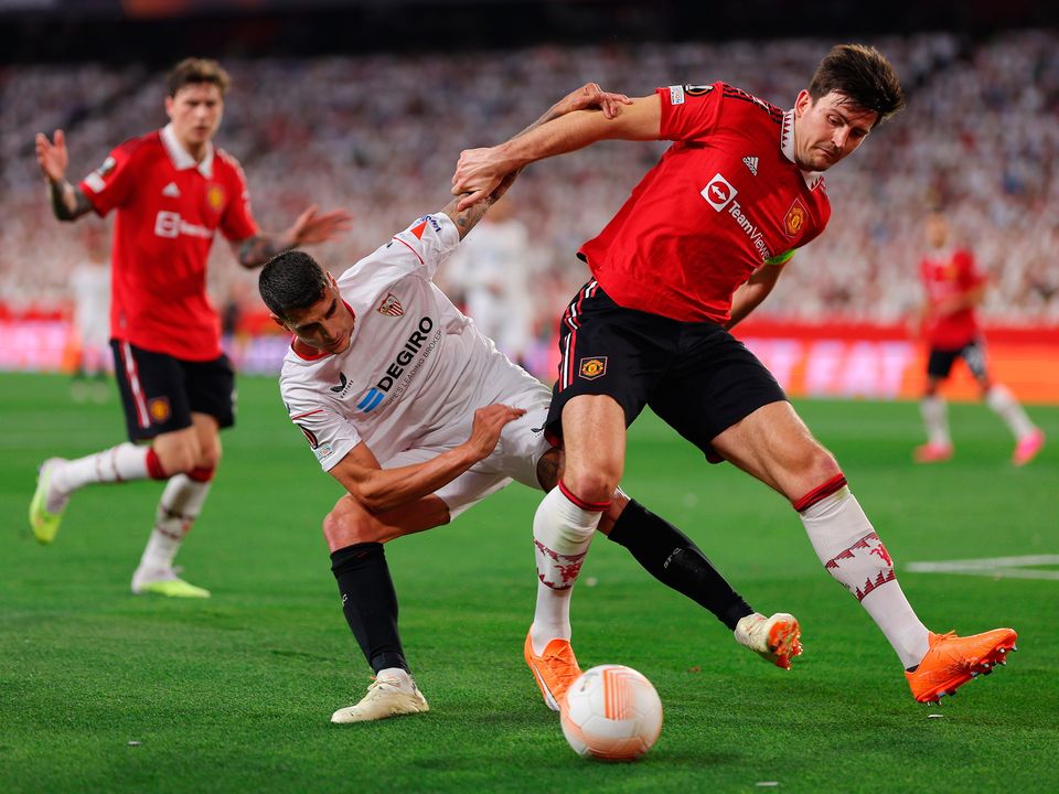 SEVILLE, SPAIN - APRIL 20: Harry Maguire of Manchester United is challenged by Erik Lamela of Sevilla FC during the UEFA Europa League Quarterfinal Second Leg match between Sevilla FC and Manchester United at Estadio Ramon Sanchez Pizjuan on April 20, 2023 in Seville, Spain. (Photo by Fran Santiago/Getty Images)