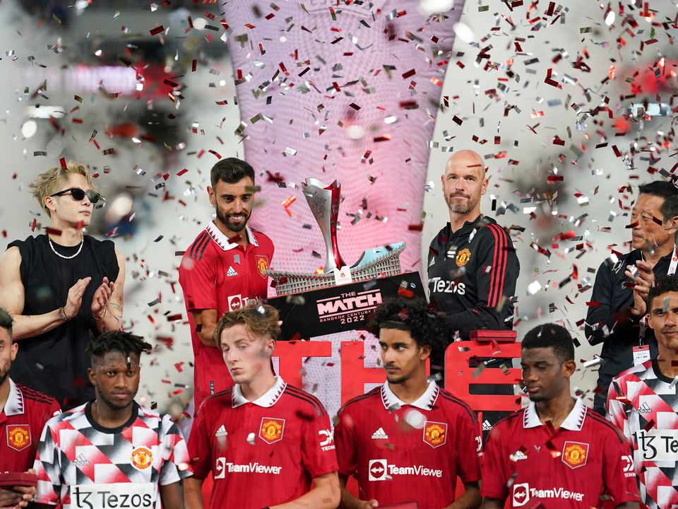 Manchester United Bruno Fernandes. second from left, and Manchester United's manager Erik ten Hag hold the trophy after winning their pre-season soccer match at the Rajamangala national stadium In Bangkok ,Thailand, Tuesday, July 12, 2022. Manchester United beat Liverpool's 4-0.(AP Photo/Wason Wanichakorn)