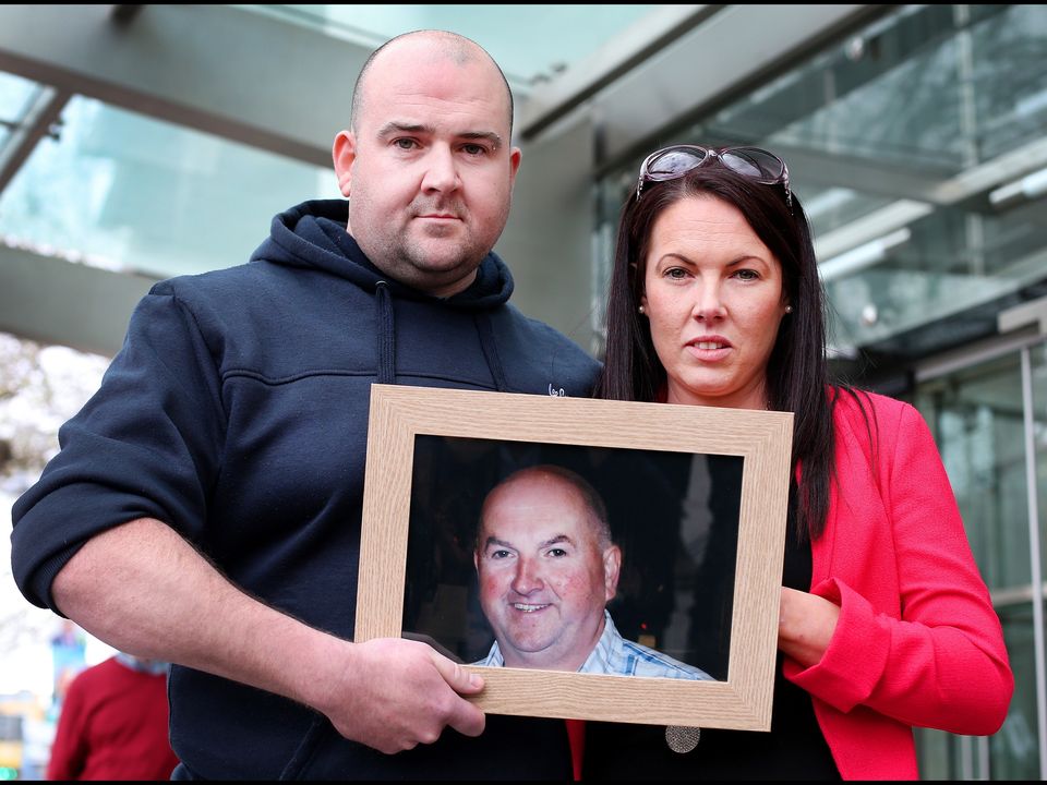 Bobby Ryan’s children, Robert and Michelle Ryan, hold a photo of their father after Patrick Quirke was convicted of his murder
