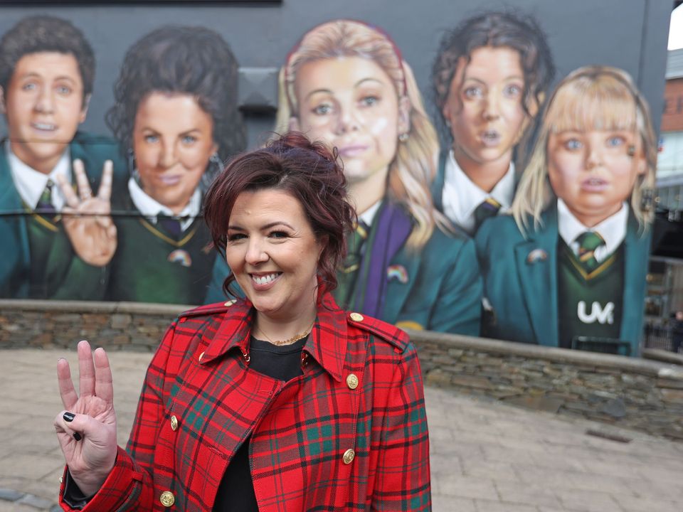 Writer Lisa McGee in front of a Derry Girls mural in Londonderry (Liam McBurney/PA)