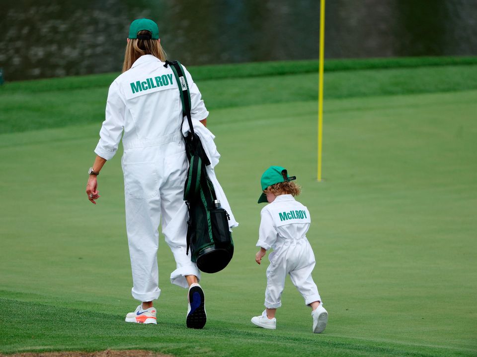 Rory McIlroy's wife Erica walks on the first green with their daughter Poppy