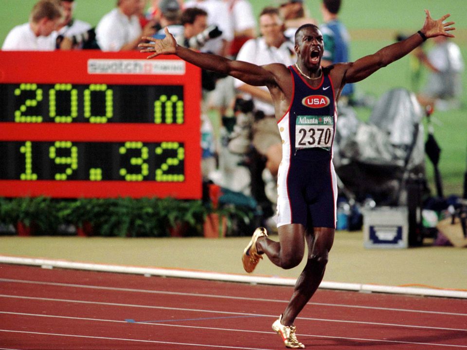 USA's Michael Johnson celebrates as he runs by the stadium clock with his new world record of 19.32 posted after he broke his old record in the men's 200 metre final at Olympic Stadium in Atlanta, August 1,1996. REUTERS BOOKS