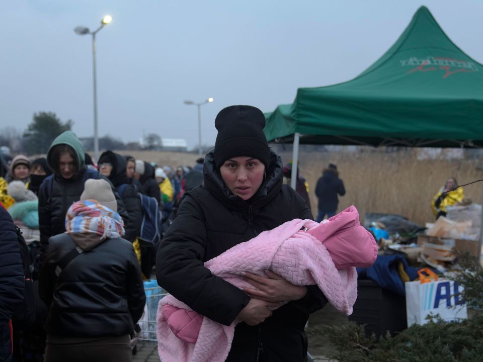 A woman with a child arrives at a border crossing in Poland (Markus Schreiber/AP)