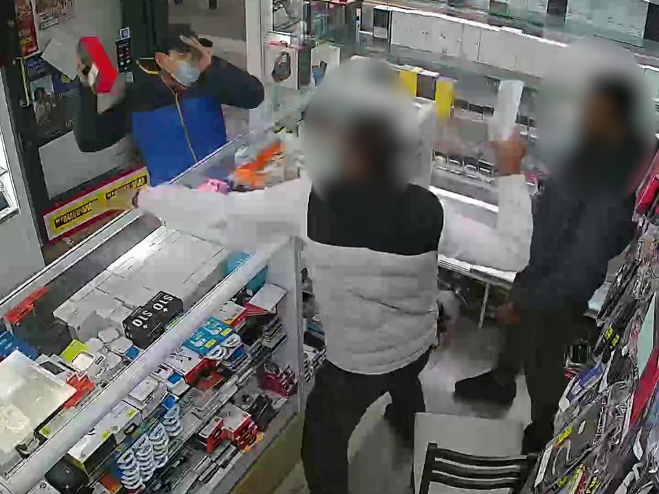 The thief grabs the phone after pepper-spraying staff