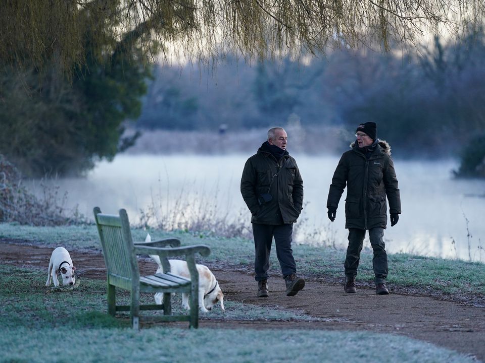Dog walkers during a cold and frosty morning. Picture date: Tuesday January 17, 2023.