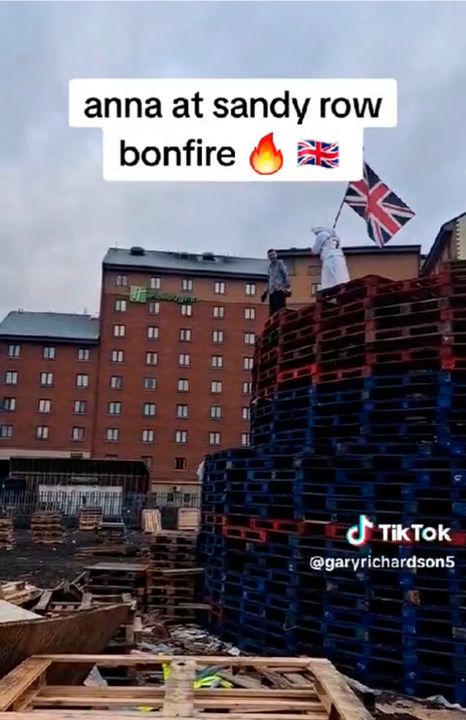 Rachel Mulcahy, aka Anna Christian, atop the bonfire at Sandy Row