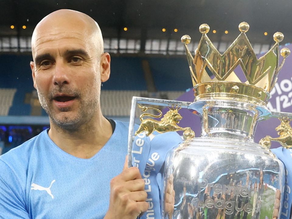 Man City manager Pep Guardiola celebrates with the trophy after winning the Premier League
