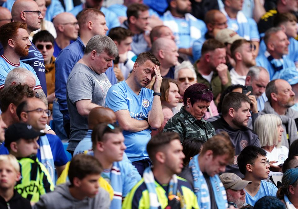 Manchester City fans look dejected with Villa leading 2-0 at the Etihad before City’s spectacular comeback (Martin Rickett/PA Images).