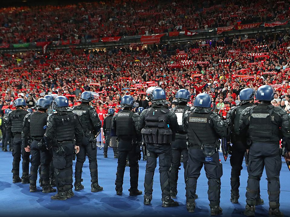 Riot police watch Liverpool FC fans during the Uefa Champions League final match at the Stade de France