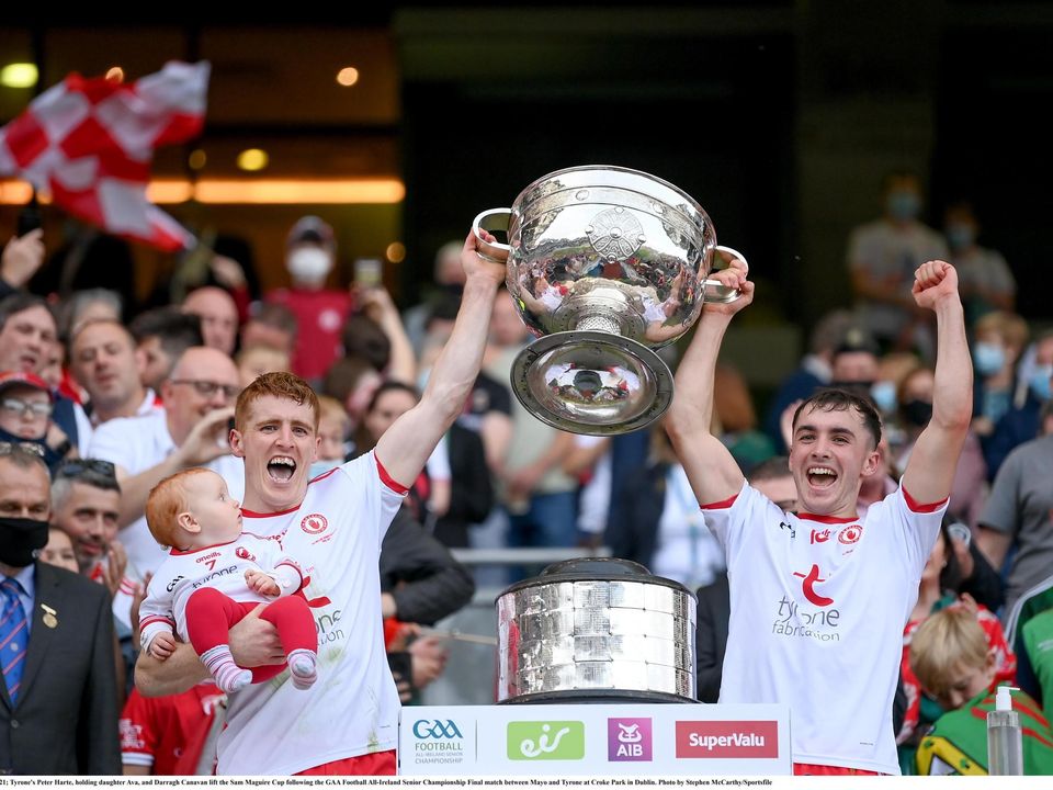 Tyrone's Peter Harte, holding daughter Ava, and Darragh Canavan lift the Sam Maguire Cup in Croke Park last year.