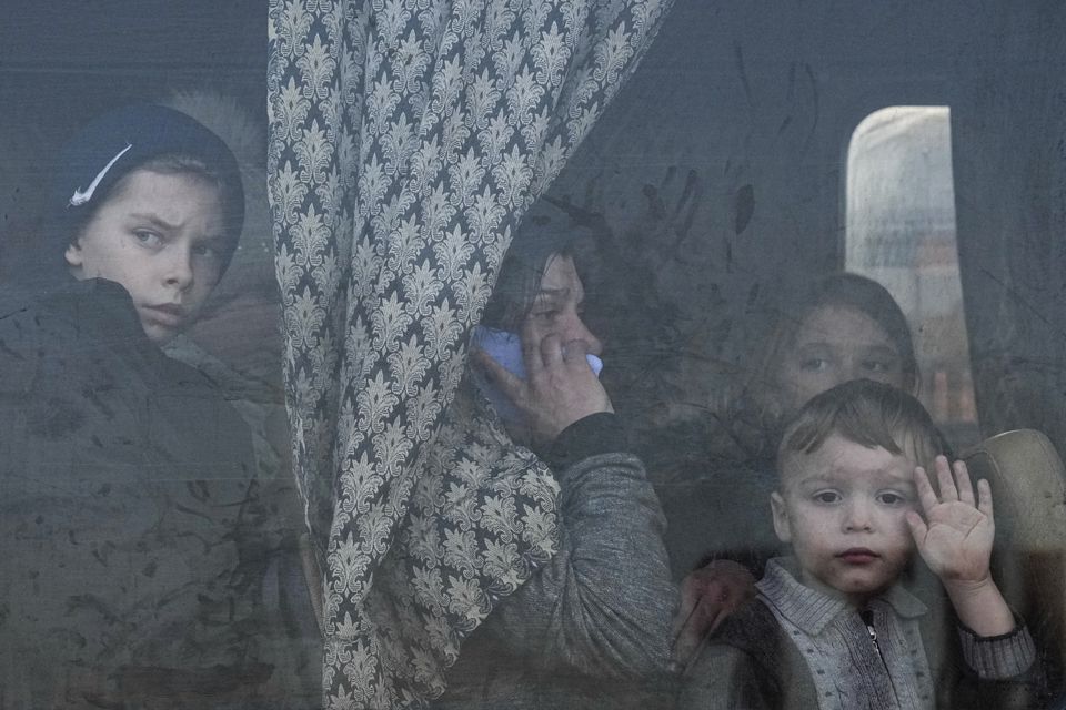 Internally displaced people look out from a bus at a refugee centre in Zaporizhia, Ukraine, in March 2022 (Evgeniy Maloletka/AP/PA)