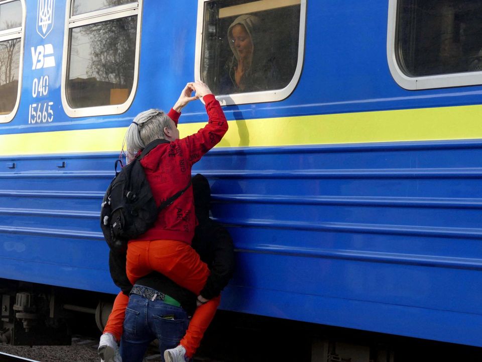 People say goodbye to their relative who is aboard a train travelling to Przemysl, Poland, amid Russia's invasion of Ukraine, in Odesa, Ukraine, April 25, 2022. REUTERS/Igor Tkachenko