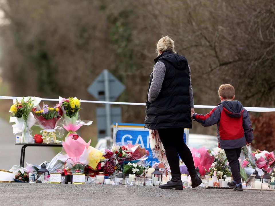 People pay their respects at the entrance leading to the scene of Ashling Murphy's murder on the Grand Canal in Tullamore. Photo: Gerry Mooney