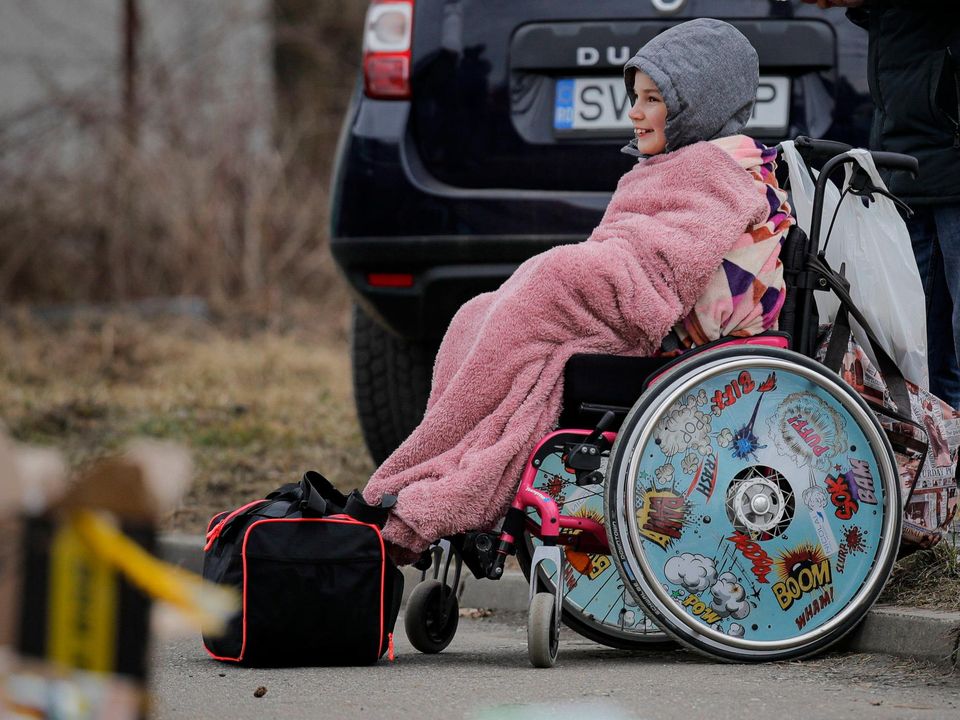 A child in a wheelchair who fled the conflict from neighbouring Ukraine waits for transport at the Romanian-Ukrainian border, in Siret, Romania. Picture: AP