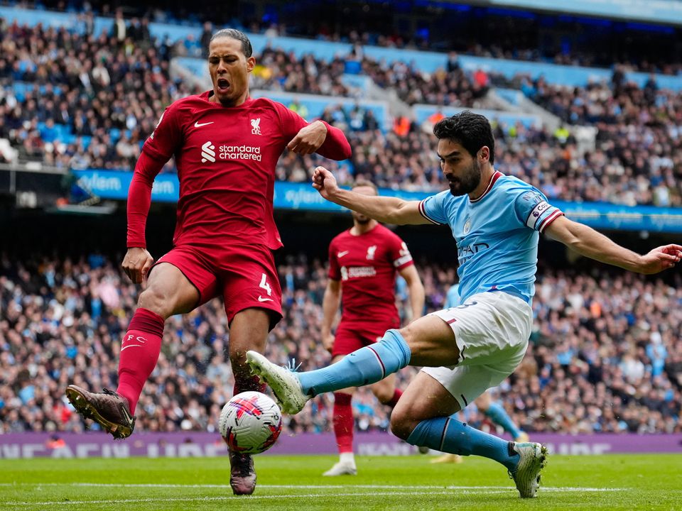 Manchester City's Ilkay Gundogan, right, challenged by Liverpool's Virgil van Dijk, scores their third goal. AP Photo/Jon Super